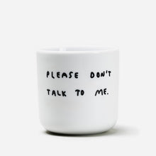 Weißer henkelloser Porzellan-Becher mit einer einfachen schwarzen Illustration, einem handschriftlichen Text der besagt "PLEASE DON'T TALK TO ME" auf weißen Hintergrund.
