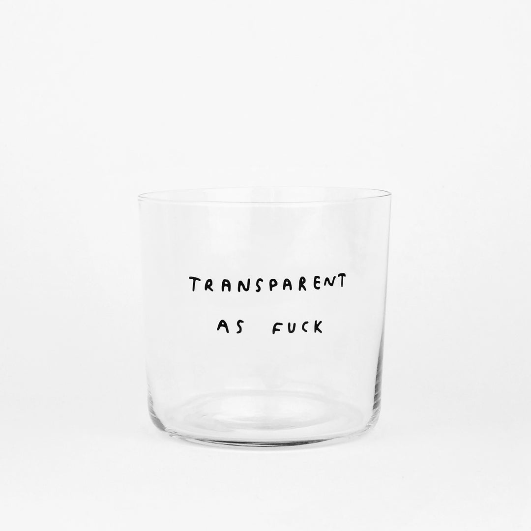 Transparentes Designer Glas mit dem Motiv transparent as fuck. Weißer Hintergrund.
