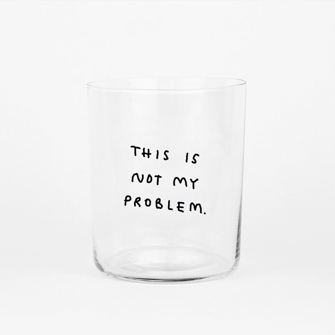Großes Designer-Trinkglas mit sehr dünnen Glaswänden und einer schwarzen, einfarbigen Illustration auf der Vorderseite. Das Motiv auf dem Glas ist eine Handschrift in Schwarz in der geschrieben ist THIS IS NOT MY PROBLEM, auf weißem Hintergrund.