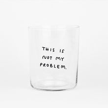Großes Designer-Trinkglas mit sehr dünnen Glaswänden und einer schwarzen, einfarbigen Illustration auf der Vorderseite. Das Motiv auf dem Glas ist eine Handschrift in Schwarz in der geschrieben ist THIS IS NOT MY PROBLEM, auf weißem Hintergrund.