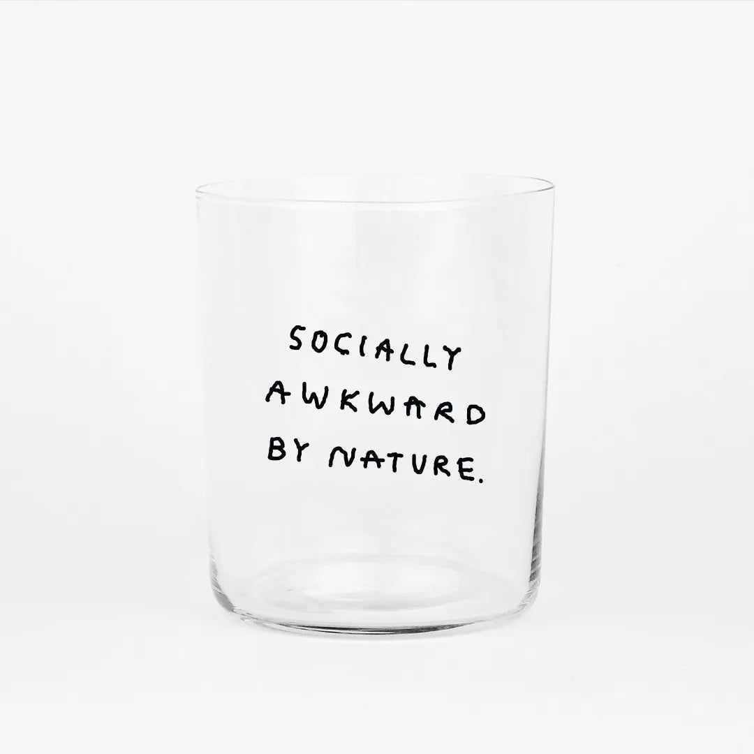 Großes Designer-Trinkglas mit sehr dünnen Glaswänden und einer schwarzen, einfarbigen Illustration auf der Vorderseite. Das Motiv auf dem Glas ist eine Handschrift in Schwarz in der geschrieben ist SOCIALLY AWKWARD BY NATURE auf weißem Hintergrund.