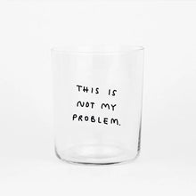Großes Designer-Trinkglas mit sehr dünnen Glaswänden und einer schwarzen, einfarbigen Illustration auf der Vorderseite. Das Motiv auf dem Glas ist eine Handschrift in Schwarz in der geschrieben ist THIS IS NOT MY PROBLEM, auf weißem Hintergrund.