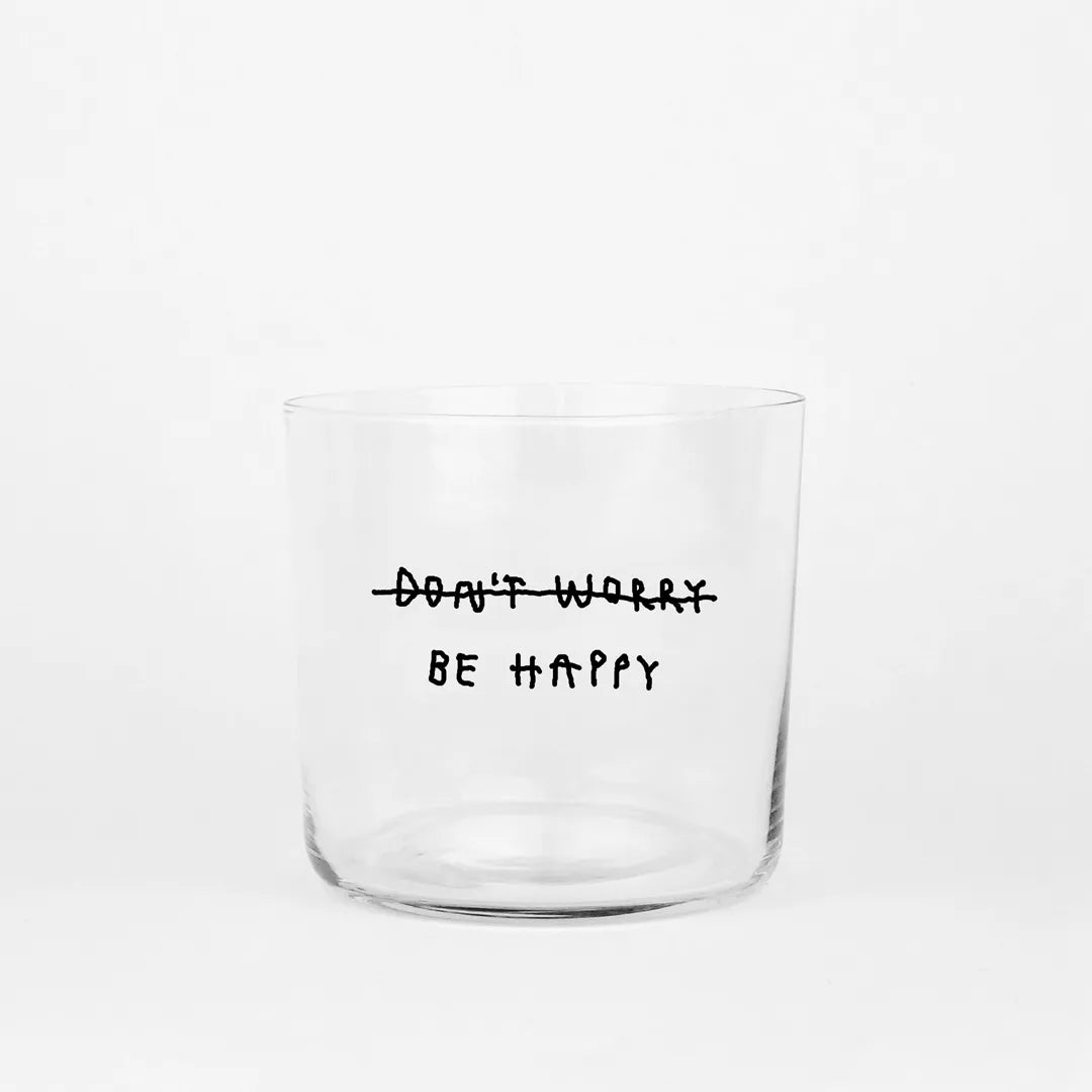 Transparentes Medium Designer Glas mit schwarzem Schriftzug "Don't worry be happy" mit dünnen Wänden und Boden. 

Das Glas ist ungefüllt vor grauem Hintergrund. 