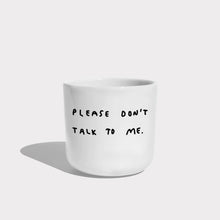 Weißer henkelloser Porzellan-Becher mit einer einfachen schwarzen Illustration, einem handschriftlichen Text der besagt "PLEASE DON'T TALK TO ME" auf weißen Hintergrund.