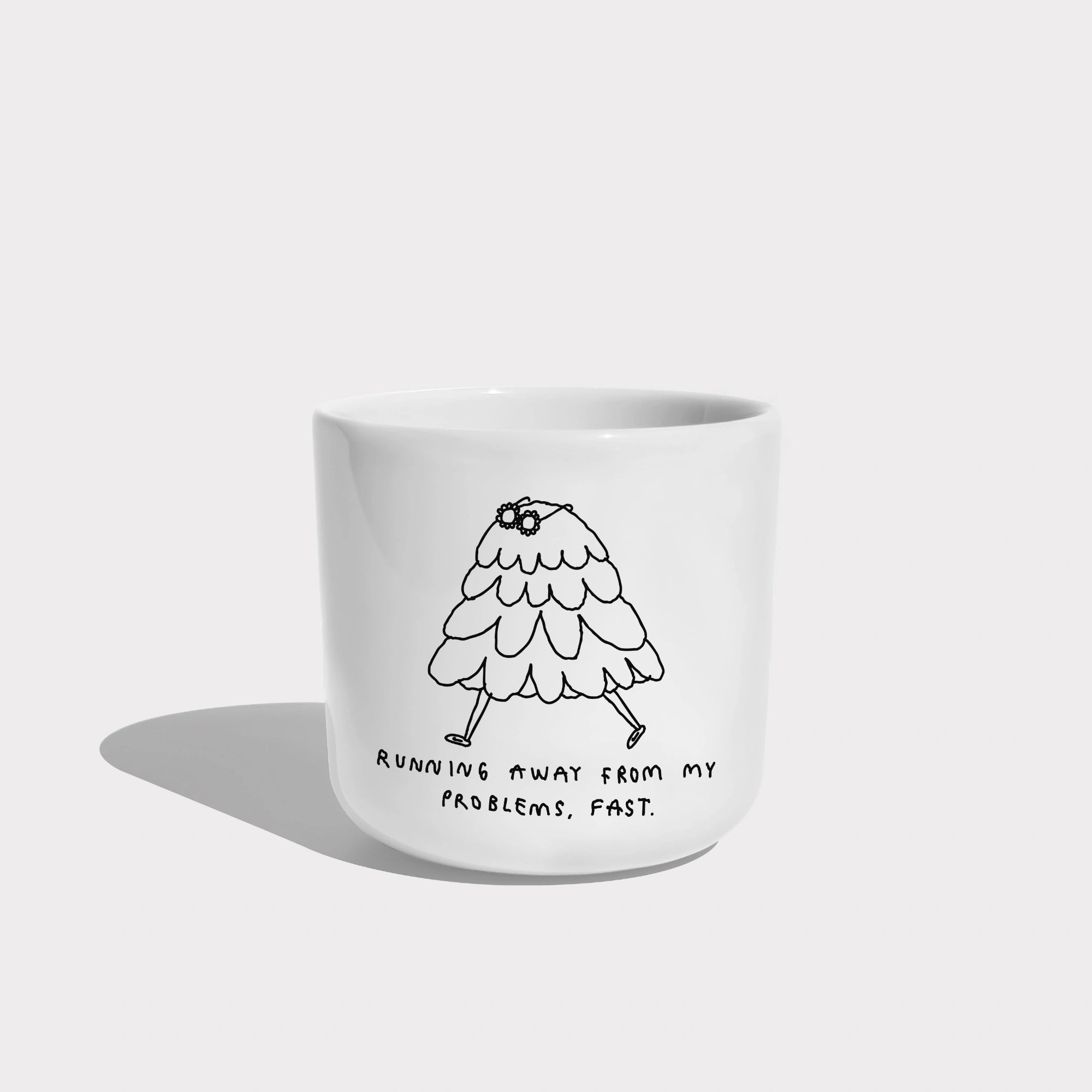 Weißer henkelloser Porzellan-Becher mit einer einfachen schwarzen Illustration einer kleinen, flauschigen, cartoonartigen Figur mit Beinen, die davonläuft. Unter der Zeichnung steht in handschriftlicher Schrift der Satz: „Running away from my problems, fast.“ (Deutsch: „Ich renne schnell vor meinen Problemen davon.“).