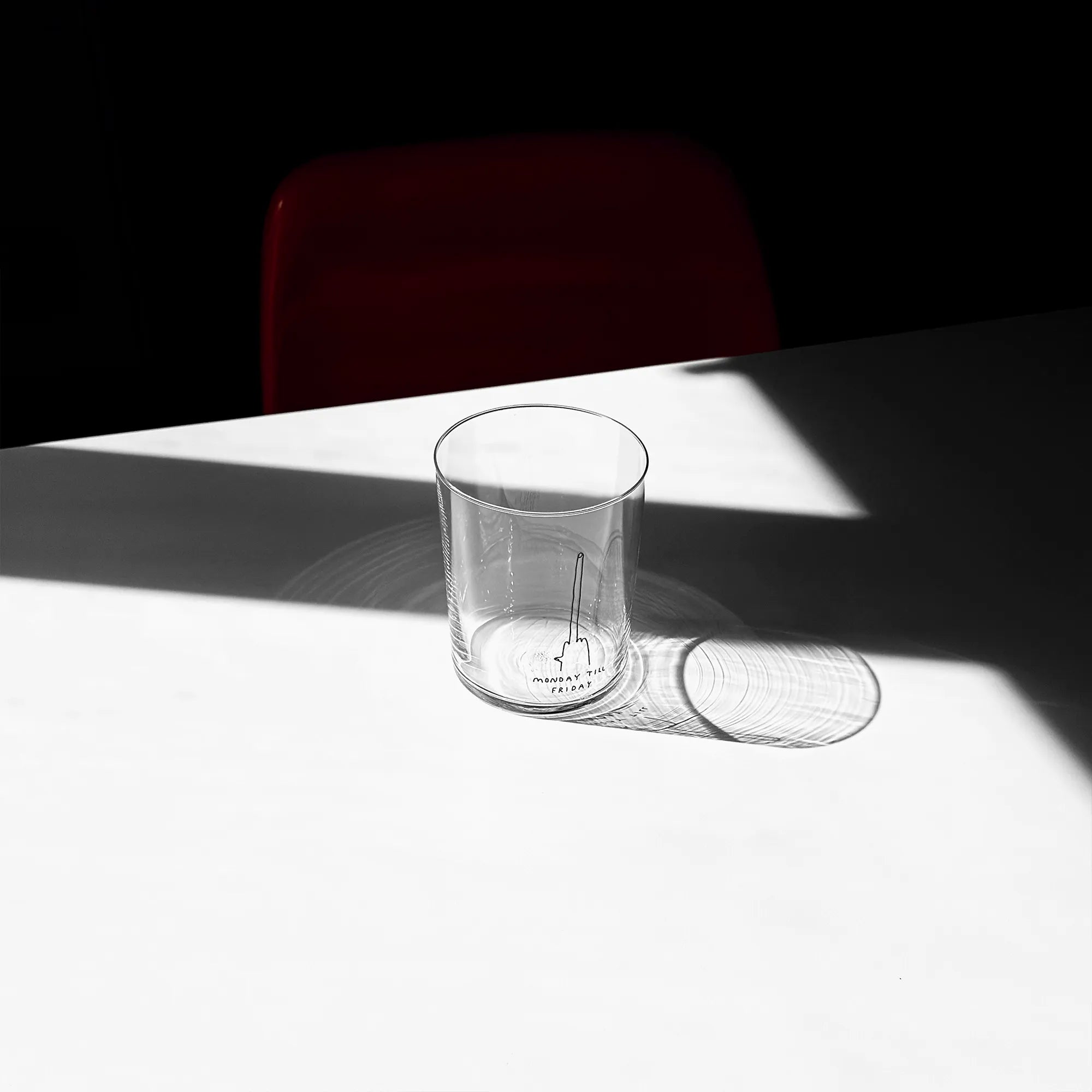 Großes Designer-Trinkglas mit sehr dünnen Glaswänden und einer schwarzen, einfarbigen Illustration auf der Vorderseite mit dem Motiv „Monday till Friday“. Illustration von Künstlerin, Illustratorin und Co-Gründerin Johanna Schwarzer.

Das Glas steht auf einem weißen Tisch, das Foto ist in einer Nahaufnahme, das Glas ist mit einer klaren Flüssigkeit befüllt. 