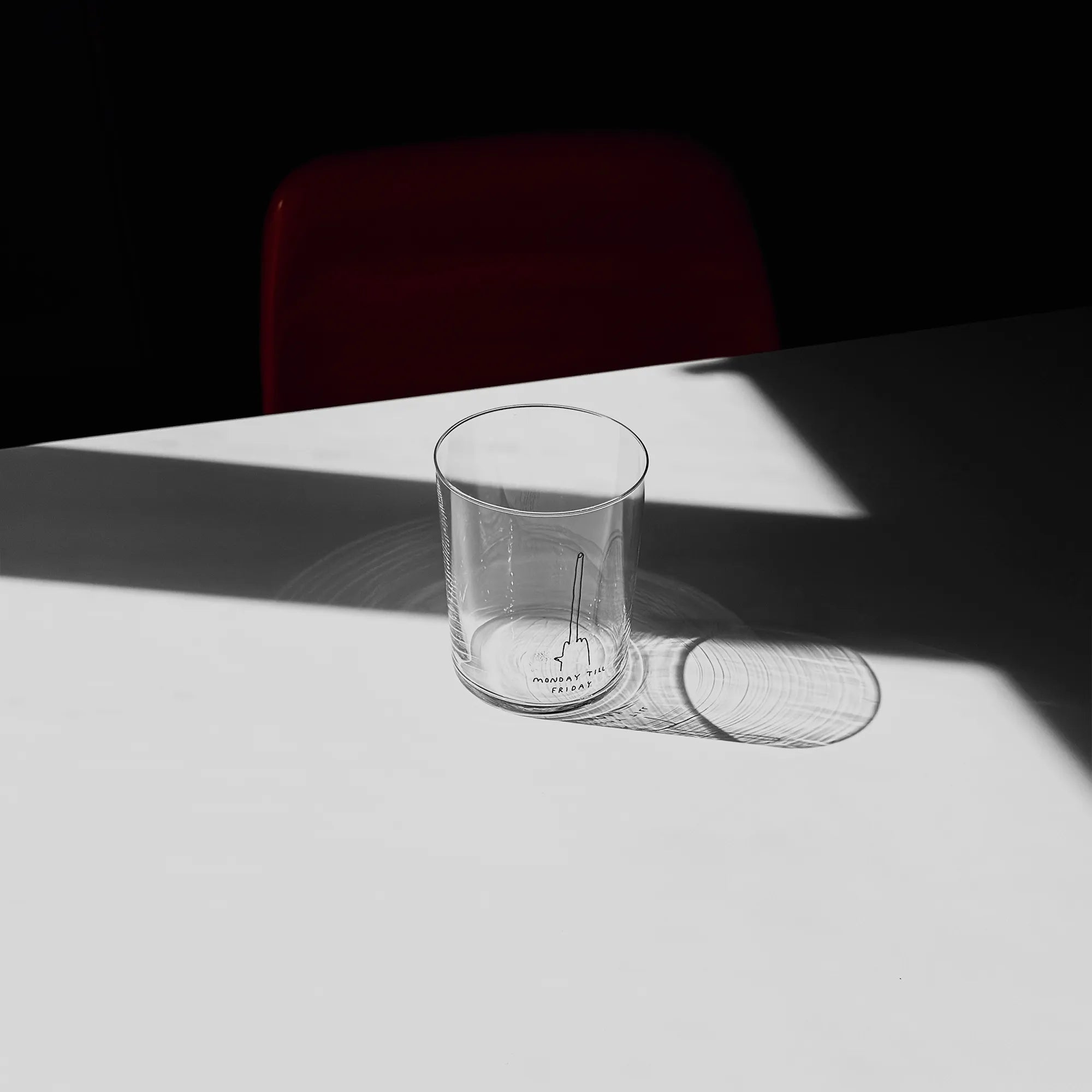 Großes Designer-Trinkglas mit sehr dünnen Glaswänden und einer schwarzen, einfarbigen Illustration auf der Vorderseite mit dem Motiv „Monday till Friday“. Illustration von Künstlerin, Illustratorin und Co-Gründerin Johanna Schwarzer.

Das Glas steht auf einem weißen Tisch, das Foto ist in einer Nahaufnahme, das Glas ist mit einer klaren Flüssigkeit befüllt. 