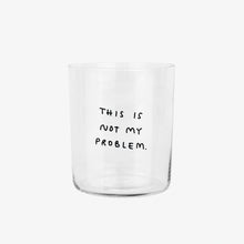 Großes Designer-Trinkglas mit sehr dünnen Glaswänden und einer schwarzen, einfarbigen Illustration auf der Vorderseite. Das Motiv auf dem Glas ist eine Handschrift in Schwarz in der geschrieben ist THIS IS NOT MY PROBLEM, auf weißem Hintergrund.