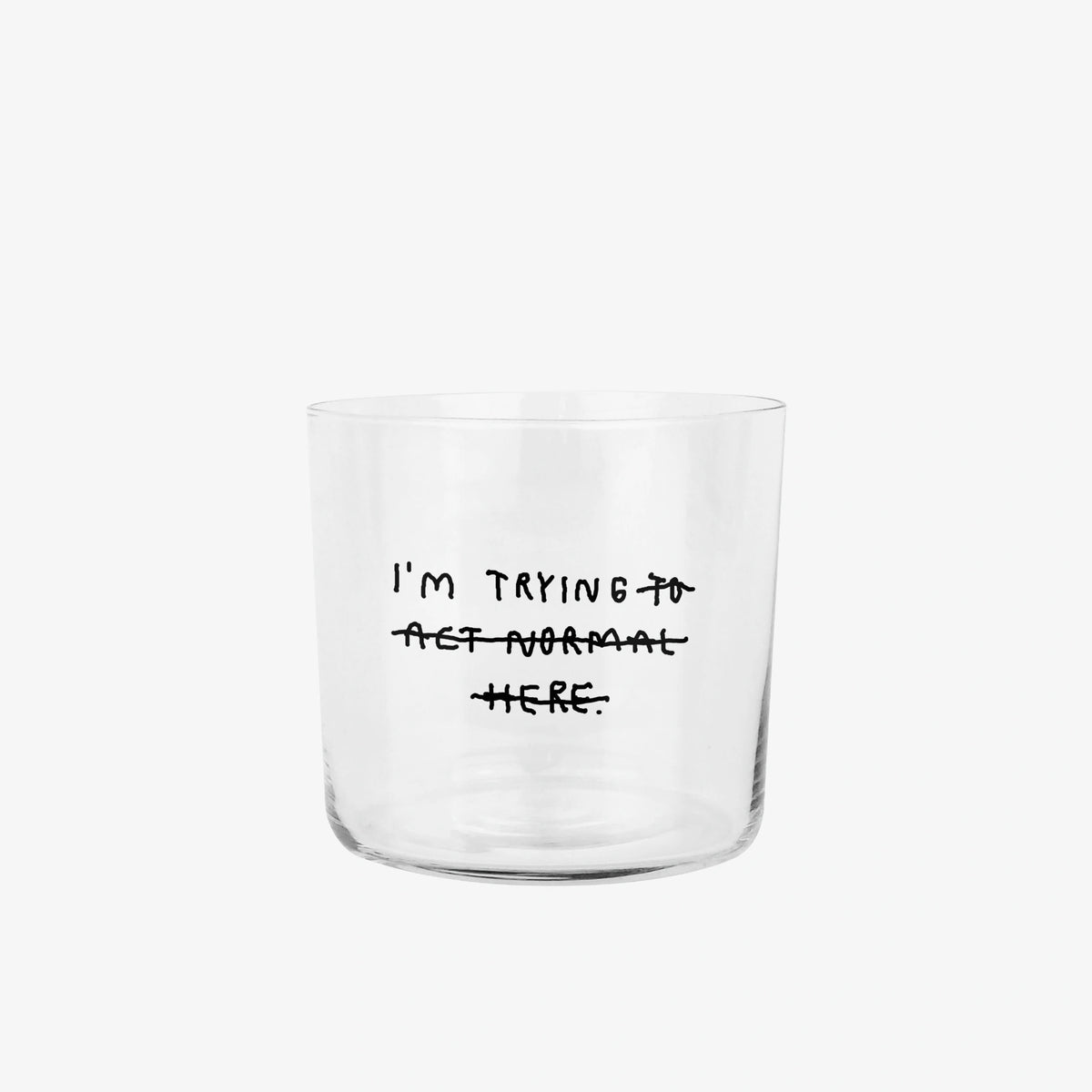 Transparentes Medium Designer Glas mit schwarzem Schriftzug "i'm trying to act normal here" mit dünnen Wänden und Boden. Dabei ist das "to act normal here durchgestrichen, so dass lediglich die Aussage "I'm trying" steht.

Das Glas ist unbefüllt und steht vor einem grauen Hintergrund-